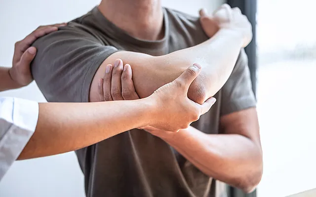 Mann wird am Ellbogen behandelt